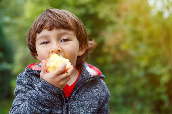 Kind isst Apfel